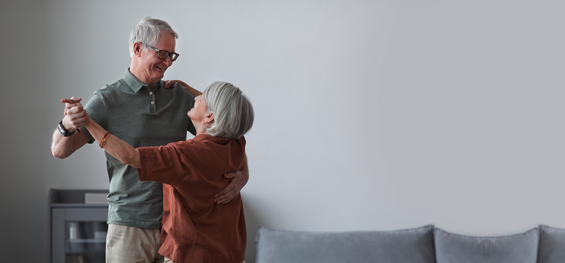 A happy mature couple dancing in their sunlit home